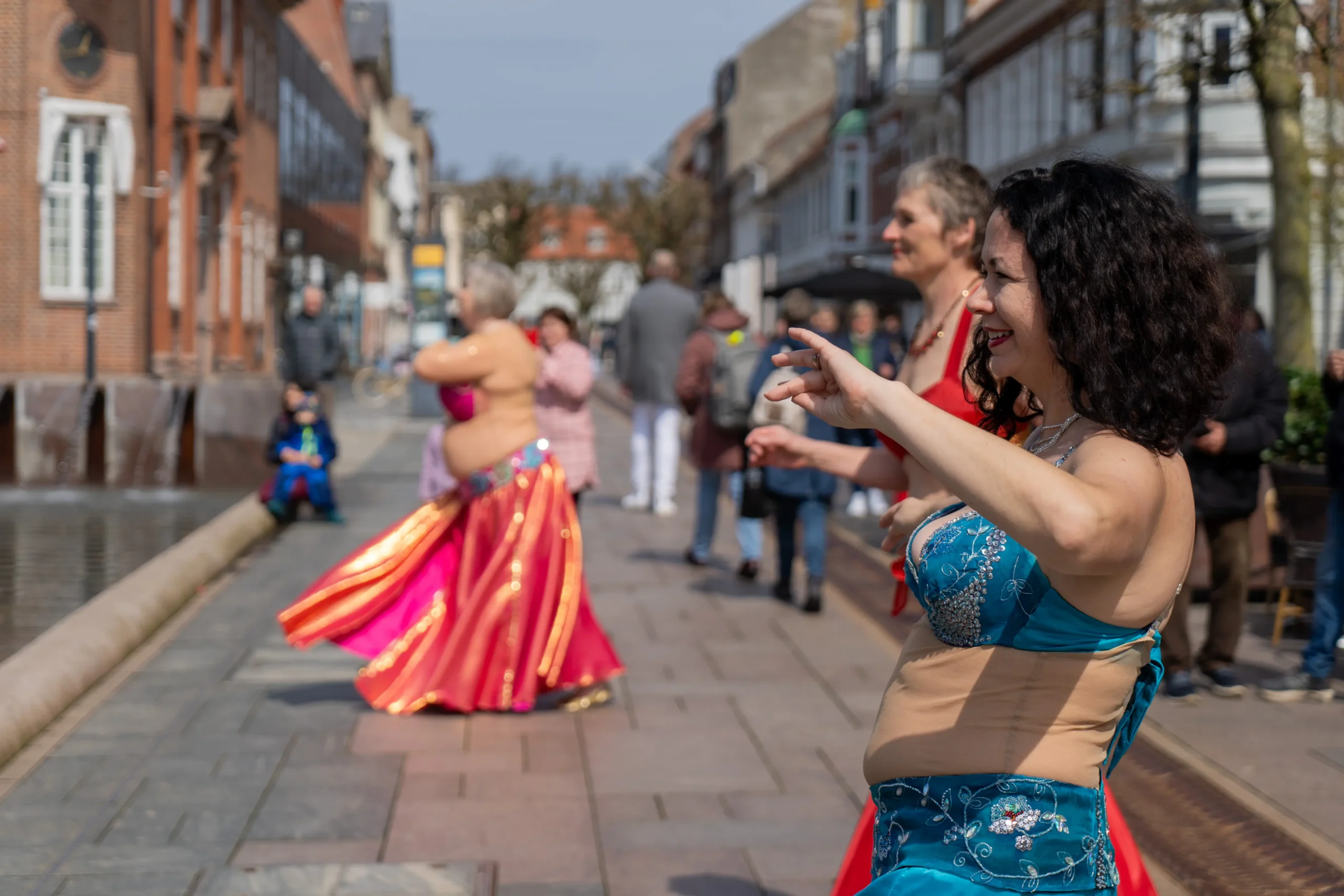 mavedansere danser mellem de handlende på gågaden.