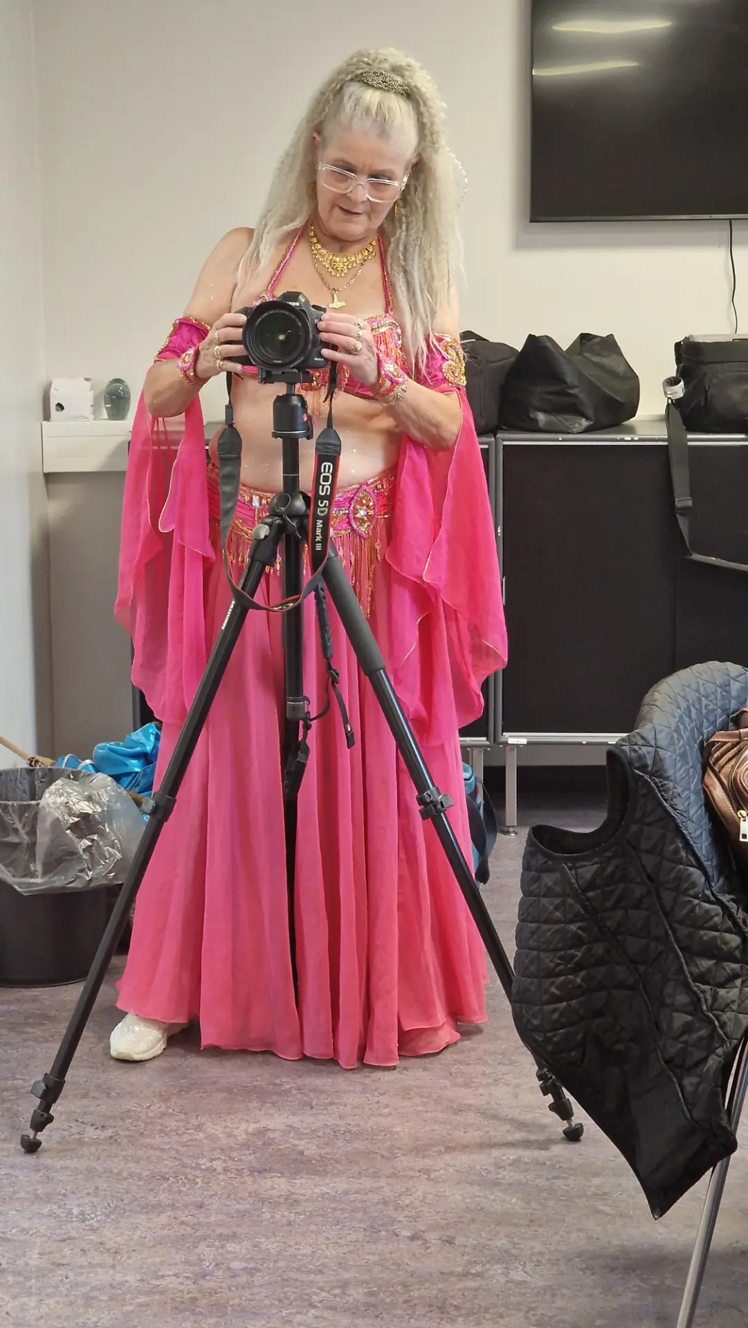 Aziza indstiller sit kamera på et stativ i omklædningsrummet før fotosessionen.