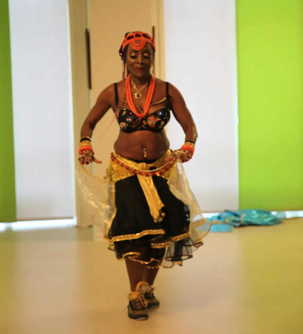 Queenie i traditionelt afrikansk kostume og hvid ansigtsmaling under fremførelsen af en kraftfuld nigeriansk dans ved Bellydance Dream Hafla 2025.