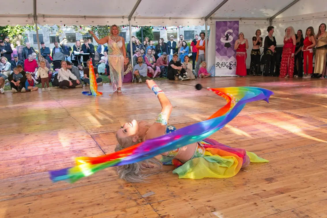 Aziza danser med regnbuefarvede poi i sol ved Århus Festuge 2025