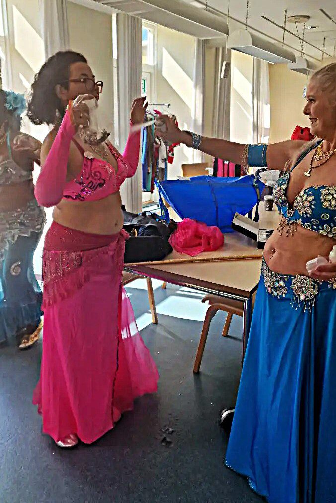 En gruppe mavedansere er ved at lægge sidst hånd på kostume, makeup og glimmer