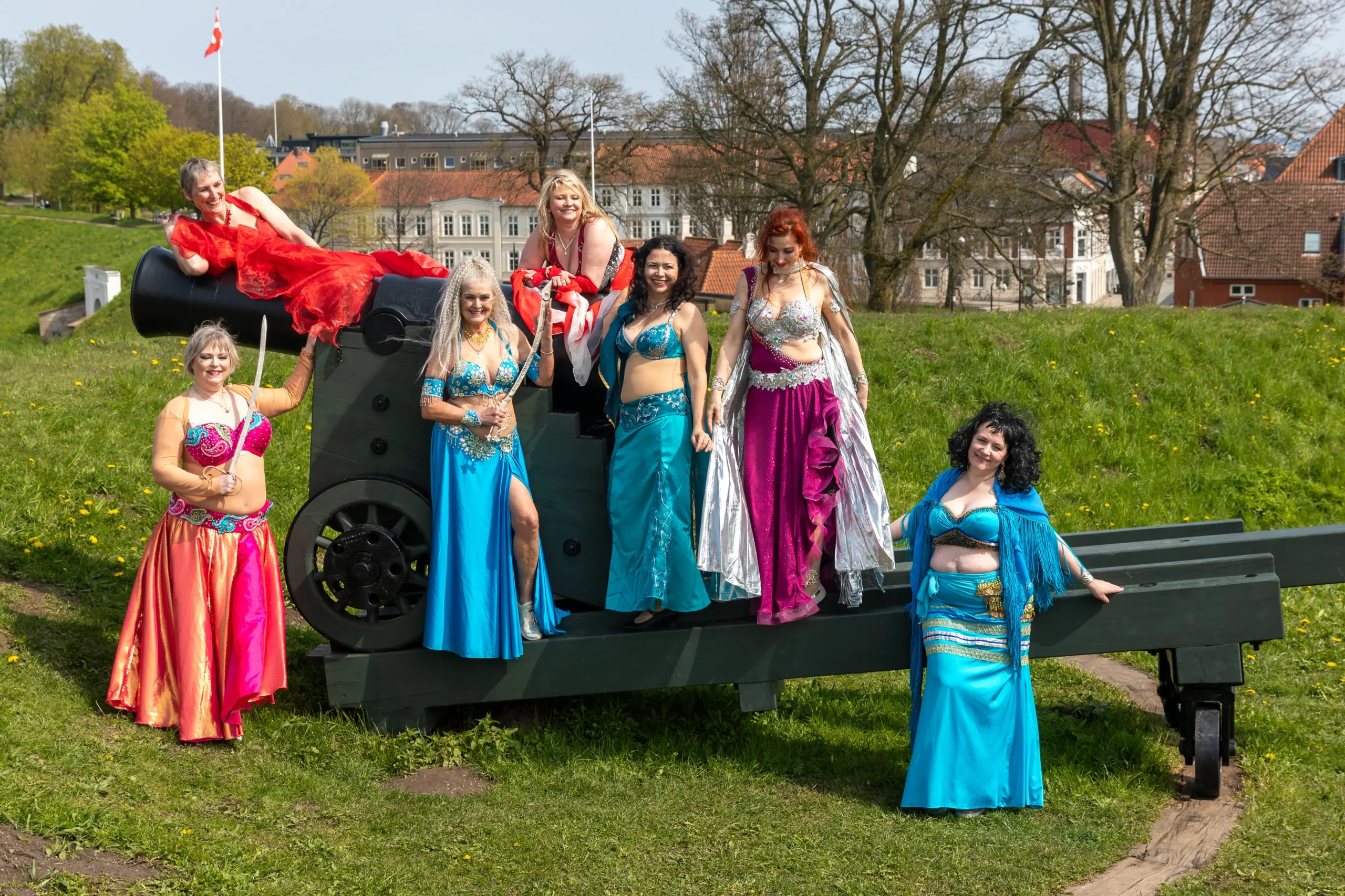 Mavedans for Alle: Dansere i smukke kostumer poserer ved kanon på Fredericia Fæstningsanlæg.