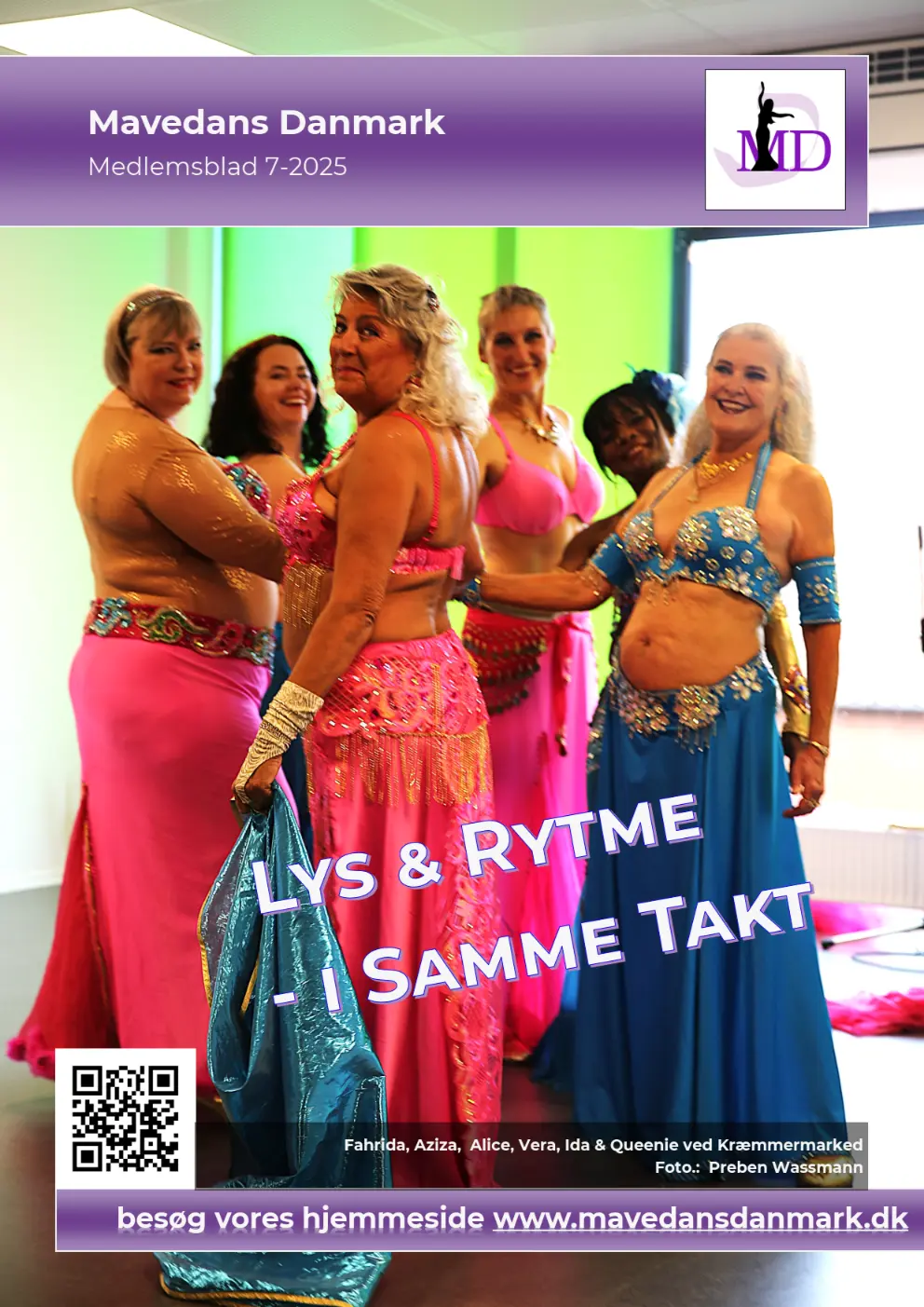 Farverig mavedansere med glitrende kostumer står i en ring