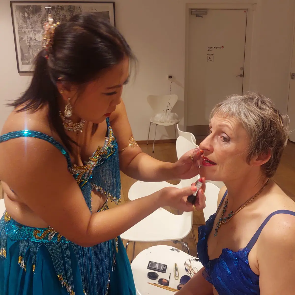 Backstage på Kolding Bibliotek: Dyna hjælper Ida med makeup før Ensemble Amiras mavedans‑show