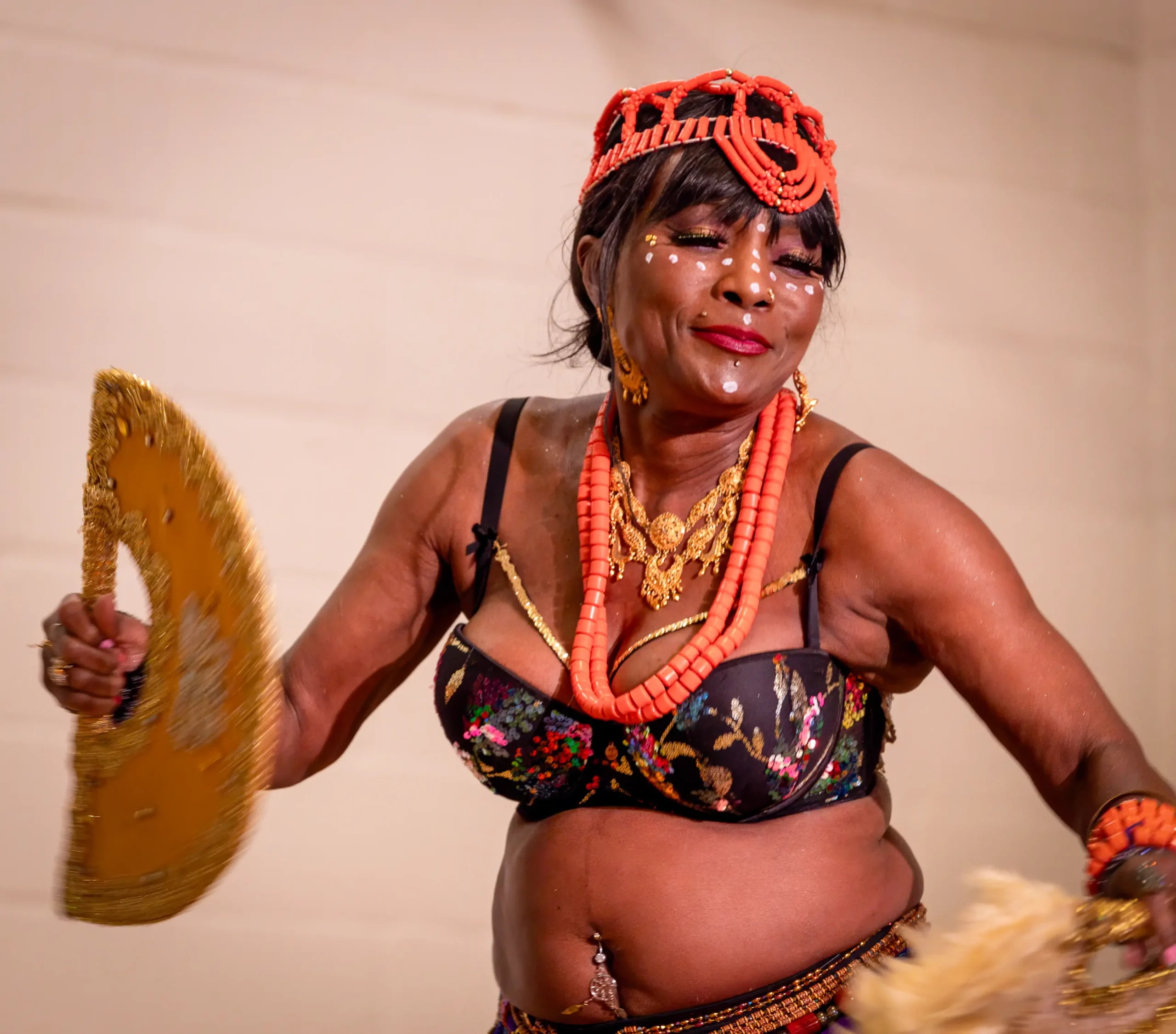 Queenie i kraftfuld afrikansk dans med vifter, perlekæder og hvide ansigtsaftegninger ved Bellydance Dream Hafla 2026.