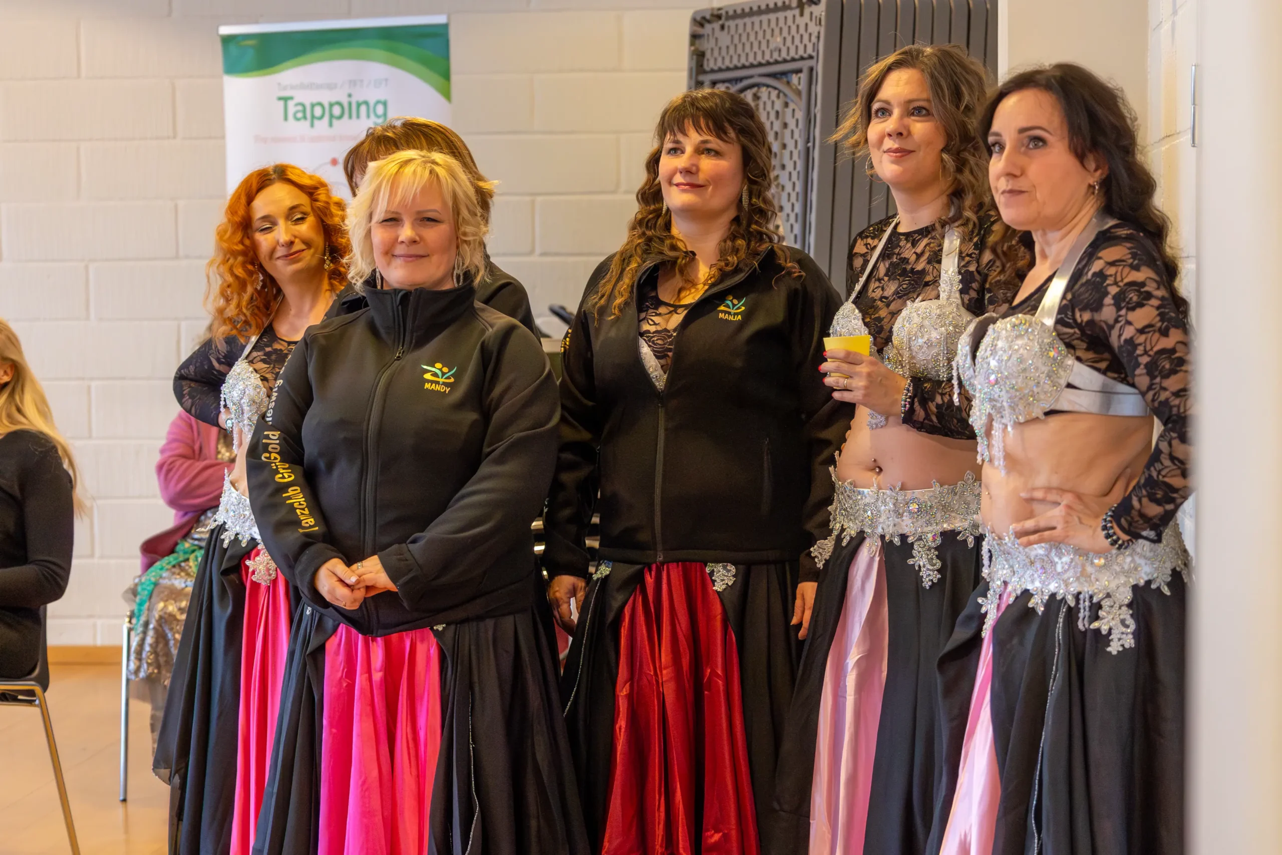 De tyske dansere står ved døren til omklædningen og ser på showet.